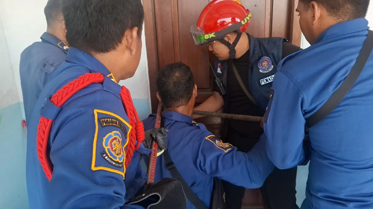 Personel Damkarla Kabupaten Gresik saat melakukan proses evakuasi dan penyelamatan seorang balita yang terkunci di dalam kamar kos di Kelurahan Kramat Inggil, Kecamatan Gresik. (Ist/Radar Gresik) 
