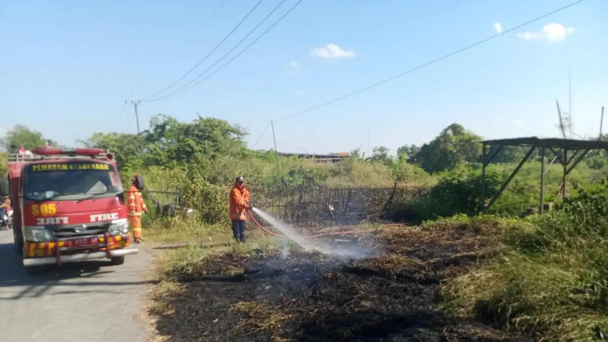 KEBAKARAN LAHAN : Petugas Damkarla Kabupaten Gresik saat melakukan pemadaman kebakaran lahan Alang - Alang di kawasan Jalan Mayjen Sungkono No. 1, Desa Prambangan, Kecamatan Kebomas, Kabupaten Gresik. (Ist/Radar Gresik) 