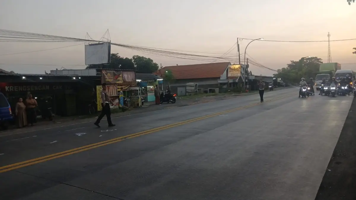 Petugas kepolisian melakukan olah TKP kecelakaan yang melibatkan bus, truk, dan sepeda motor di Jalan Raya Watangrejo, Kecamatan Duduk Sampeyan, Gresik. (Yudhi/Radar Gresik) 