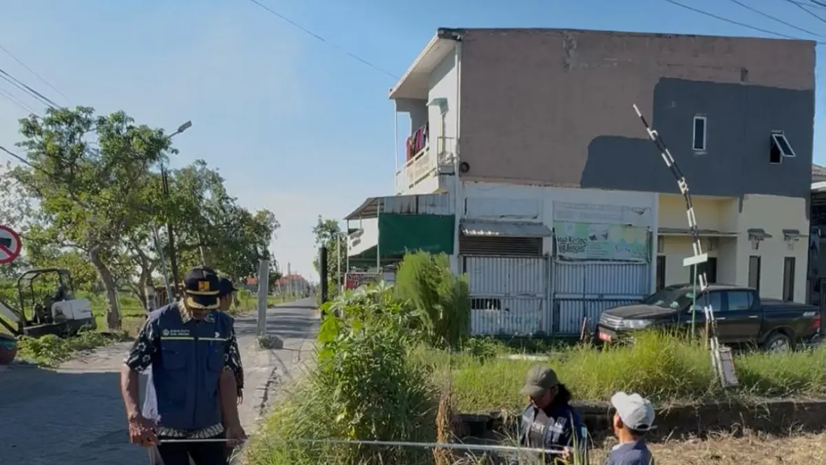 PENGUKURAN : Pegawai DPUTR Kabupaten Gresik saat pengukuran Jalan Poros Desa di Gresik. (Fajar/Radar Gresik) 
