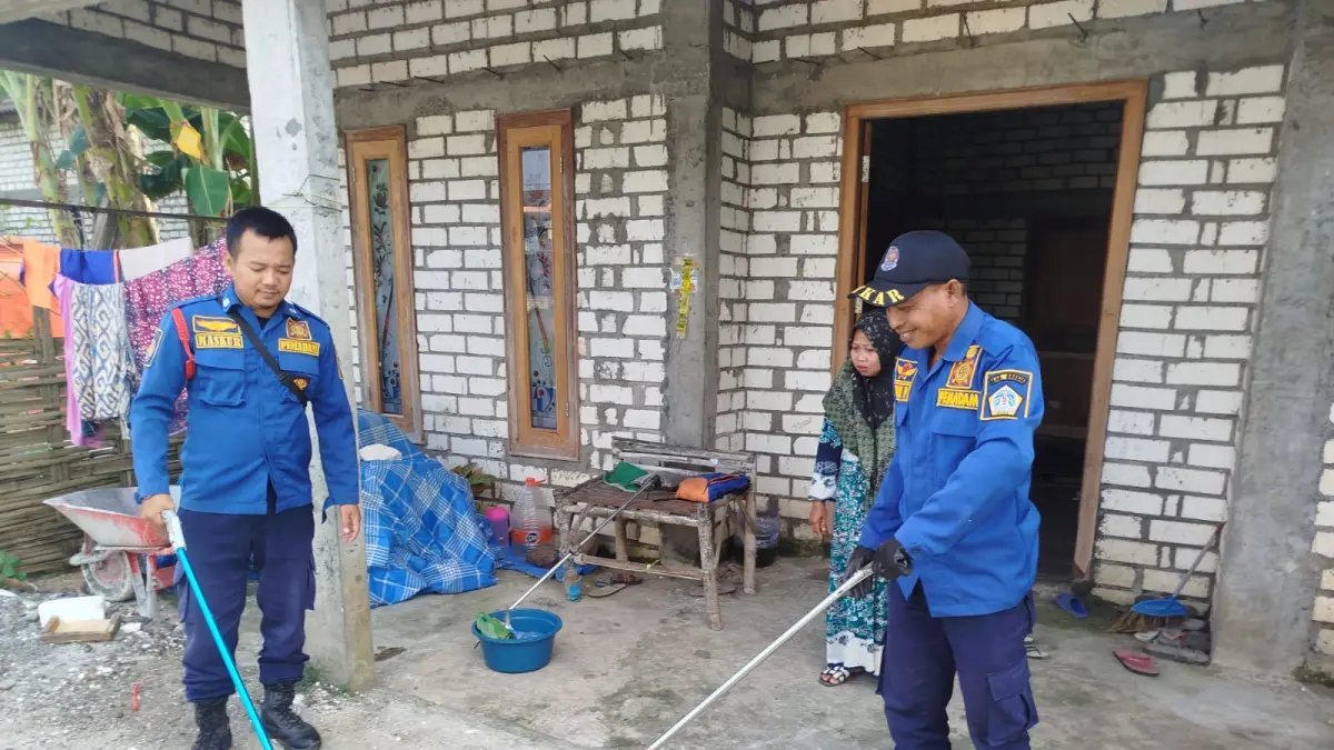 EVAKUASI : Petugas Damkarla pos Dukun saat melakukan evakuasi ular kobra yang bersembunyi di bawah kasur di kamar tidur rumah warga di Dusun Jetis, Desa Petiyin Tunggal, Kecamatan Dukun, Gresik. (Ist/Radar Gresik) 