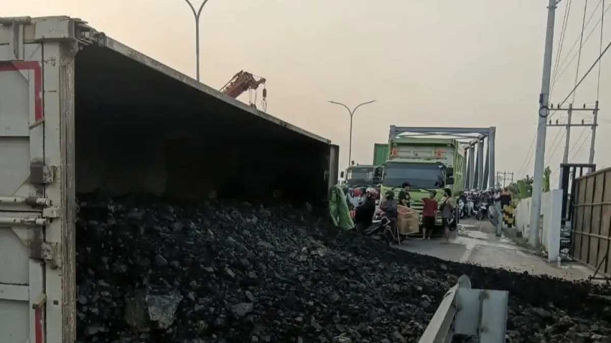 Macet : Kondisi truk bermuatan batubara saat terguling dan tumpah muatannya di Jalan Raya Daendels, tepatnya sebelum Jembatan Manyar. (Foto : Ist/Radar Gresik) 