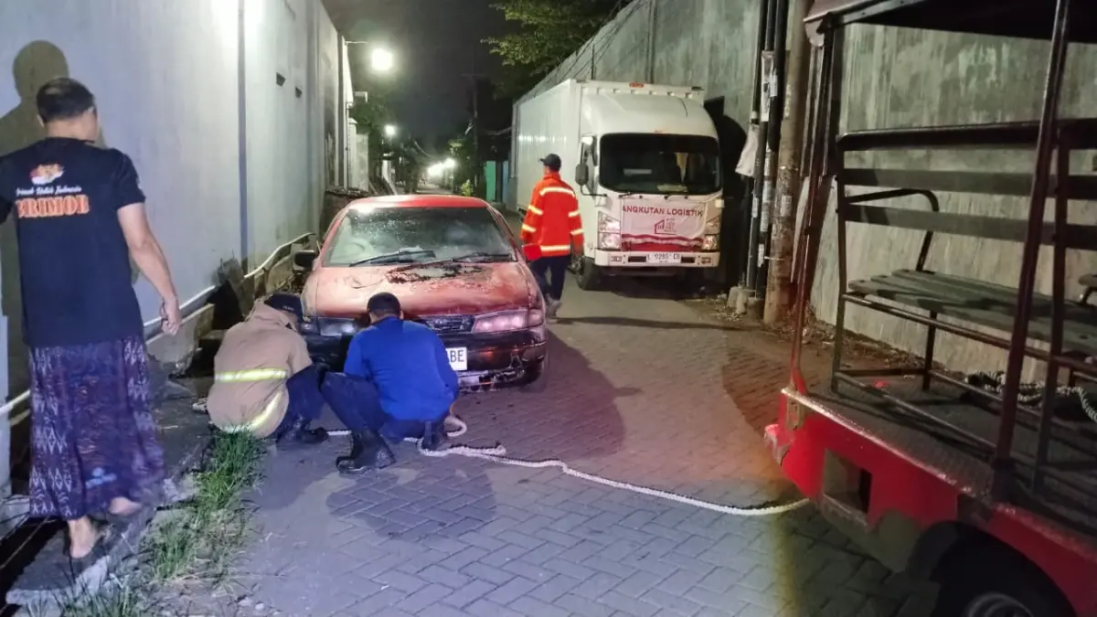 PEMADAMAN : Petugas Damkar Pos Driyorejo saat melakukan pemadaman mobil Sedan Timor yang terbakar di Jalan Raya Krikilan KM 28, Dusun Larangan, Desa Krikilan, Kecamatan Driyorejo, Gresik. (Foto : Yudhi/Radar Gresik) 
