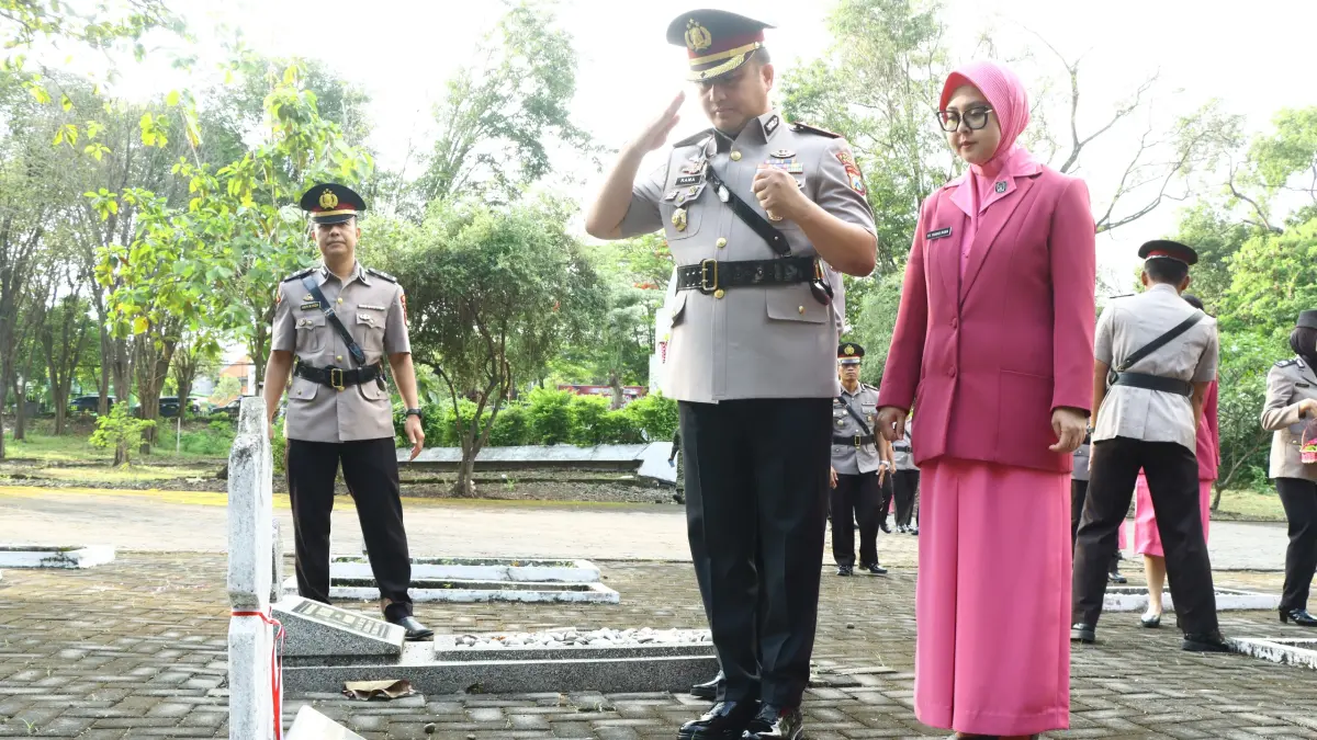 HORMAT : Kapolres Gresik AKBP Ramadhan Nasution didampingi Ketua Bhayangkari Cabang Gresik Yanggi Ramadhan saat melakukan penghormatan kepada para pahlawan di TMP, Jalan Dr. Wahidin Sudirohusodo, Kecamatan Kebomas, Gresik. (Foto : Yudhi/Radar Gresik) 