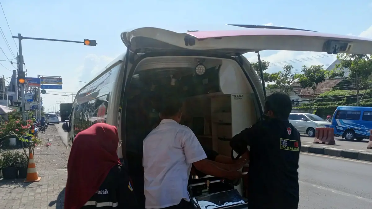 DIEVAKUASI : Petugas Damkarla Gresik saat membantu evakuasi kaki anak terjepit pintu di Jalan Raya Manyar Nomor 43, Kelurahan Manyar Rejo, Kecamatan Manyar, Gresik. (Foto : Yudhi/Radar Gresik) 