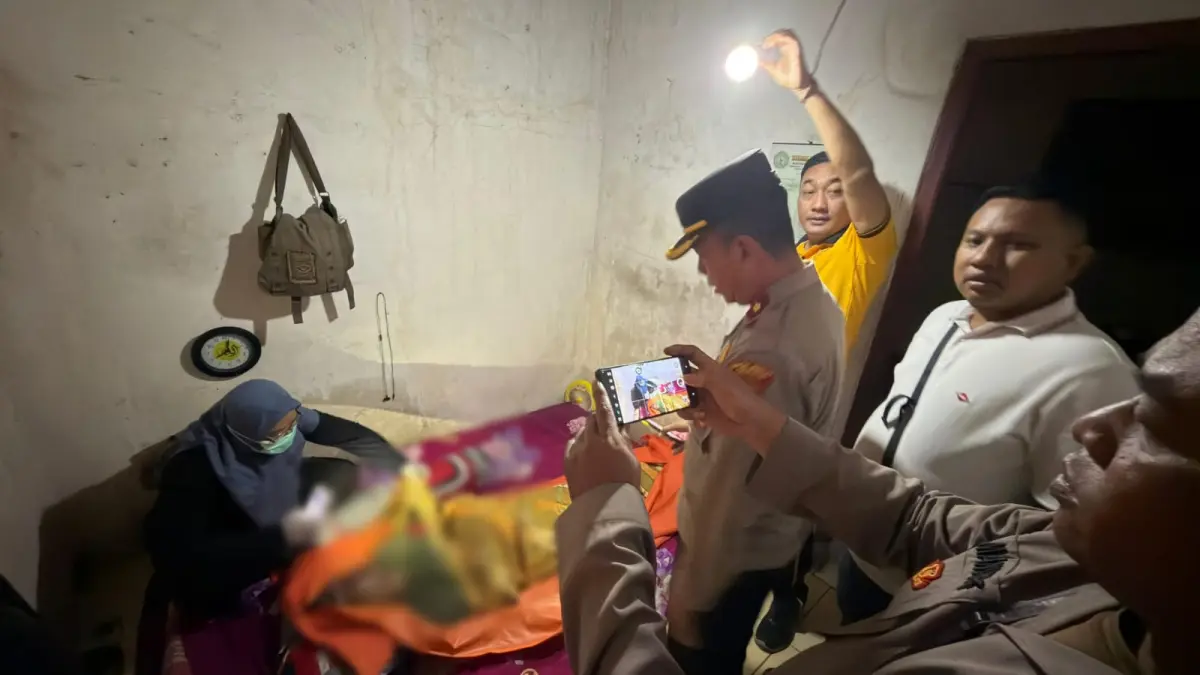 Tergeletak : Anggota Polsek Driyorejo dan tim medis saat melakukan evakuasi korban di dalam kamar kosnya di Kos Hari, Desa Kesambenwetan. (Foto : Ist/Radar Gresik)