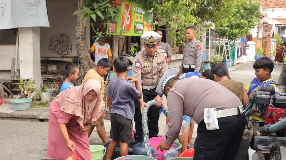 SALURKAN AIR : Anggota Polres Gresik saat menyalurkan air bersih ke warga yang membutuhkan air bersih di Desa Pandanan, Kecamatan Duduk Sampeyan, Gresik. (Foto : Ist/Radar Gresik) 