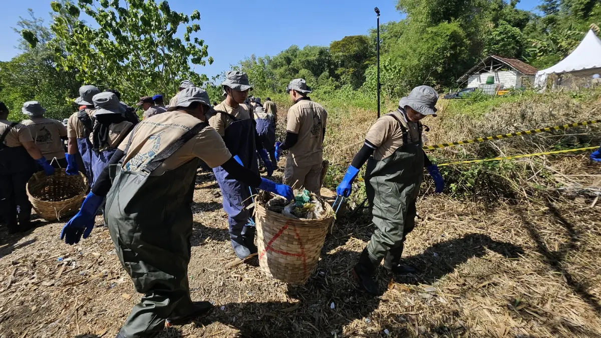 Senior Vice President Geoengineering and Environmental PT Freeport Indonesia, Ardhin Yuniar (kiri) memasukkan sampah yang telah dipungut dari pinggir pantai.