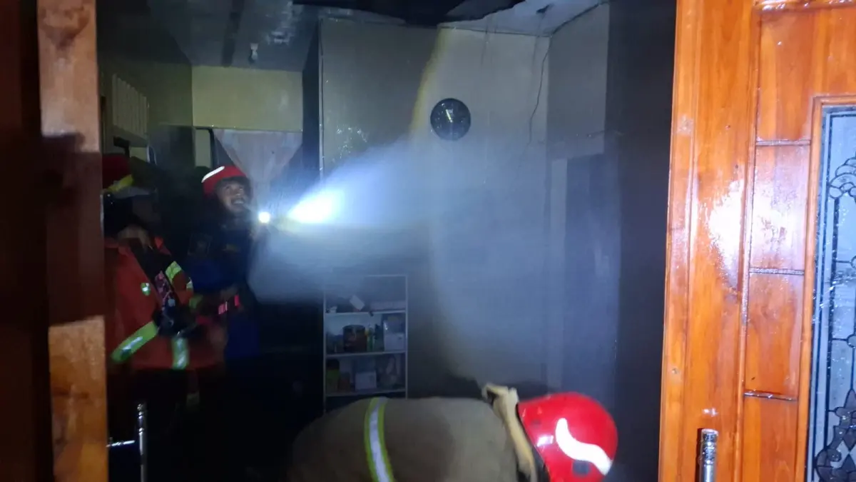 Anggota Damkar Gresik saat melakukan pemadaman rumah terbakar di Jalan Safir 3, Desa Suci, Kecamatan Manyar, Gresik. (Foto : Yudhi/Radar Gresik) 