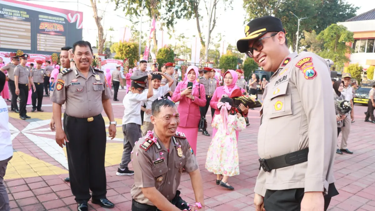 NAIK PANGKAT : Sebanyak 79 personel Polri dan 3 PNS Polres Gresik saat disemprot air mobil water cannon saat naik pangkat di halaman Mapolres Gresik. (Foto : Ist/Radar Gresik) 