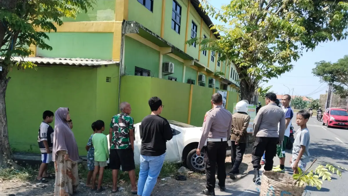 Anggota Polsek Kebomas saat membantu proses evakuasi sebuah mobil yang terperosok ke selokan di wilayah Desa Kedanyang, Kecamatan Kebomas. (Foto : Ist/Radar Gresik) 