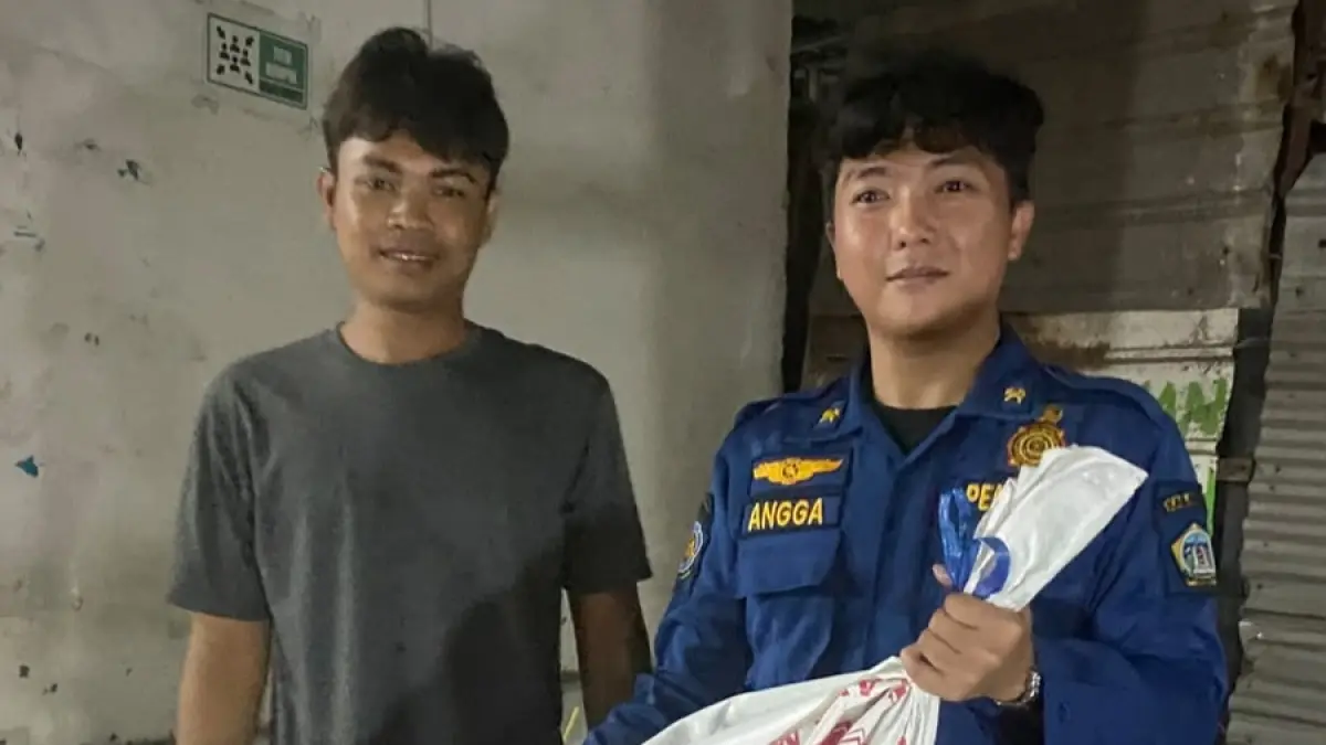 EVAKUASI: Personel Damkarla Kabupaten Gresik saat mengamankan ular sanca yang sebelumnya ditangkap warga di sebuah warung kopi di Jalan Hasan Mashum. (Foto : Yudhi/Radar Gresik) 