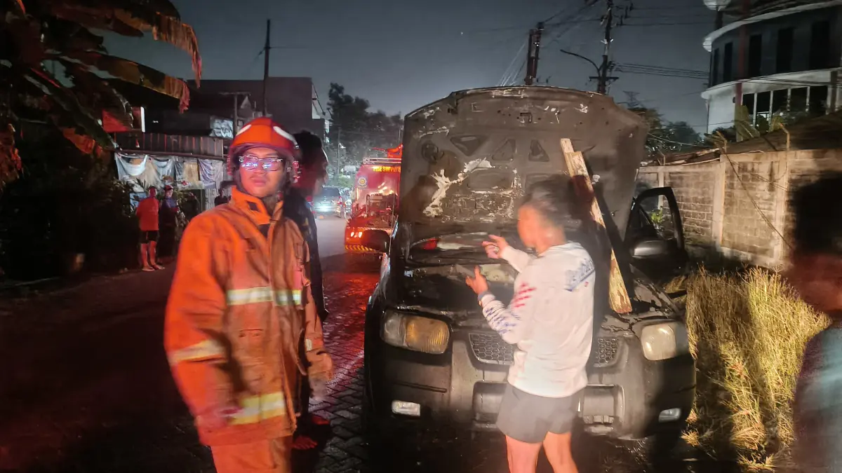 PEMADAMAN: Petugas DPKP Gresik saat berjibaku melakukan pemadaman dan pembasahan pada mobil SUV Ford Explorer yang terbakar di Jalan Harun Thohir, Kecamatan Gresik, Senin (6/7) petang. (Foto : Ist/Radar Gresikk