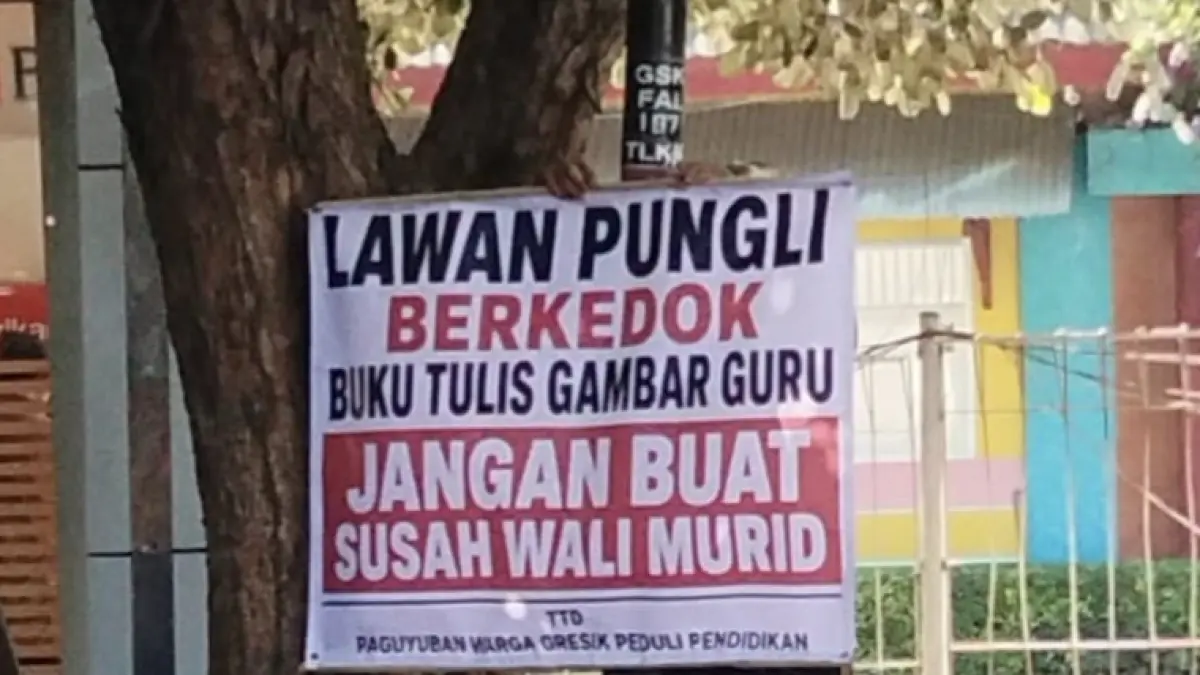 BENTANG SPANDUK: Aksi protes perlawanan wali murid saat memasang spanduk kecaman terhadap dugaan praktik pungli bermodus pembelian buku di wilayah perkotaan Gresik. (Foto : Dok/Radar Gresik) 
