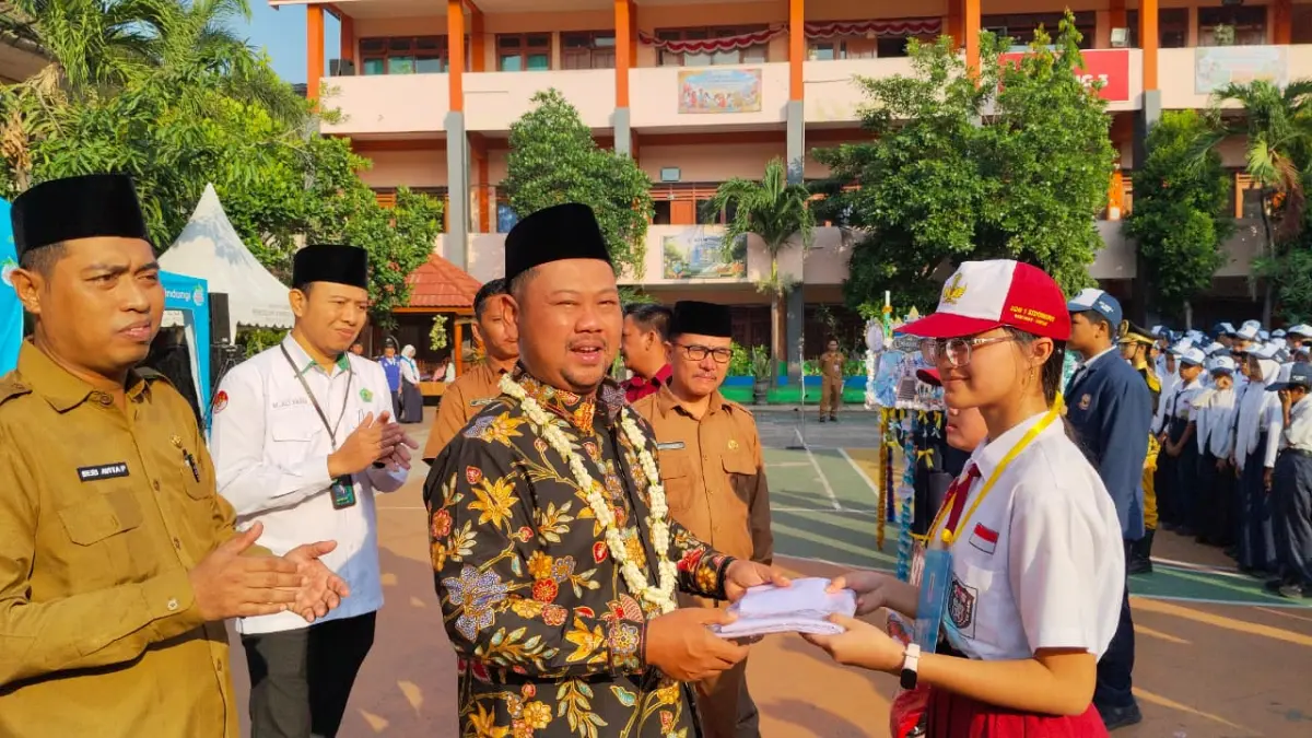Resmi : Bupati Gresik Fandi Akhmad Yani menyerahkan seragam sekolah sebagai aksi pembukaan MPLS di UPT SMPN 1 Gresik. 