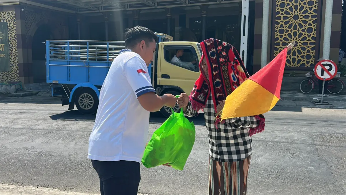 Aksi Sosial : Pegawai Rutan Kelas IIB Gresik saat meberikan bantuan sembako kepada warga Pungging yang sedang bekerja sebagai pengatur lalulintas di Jalan Raya. (Foto : Yudhi/Radar Gresik) 