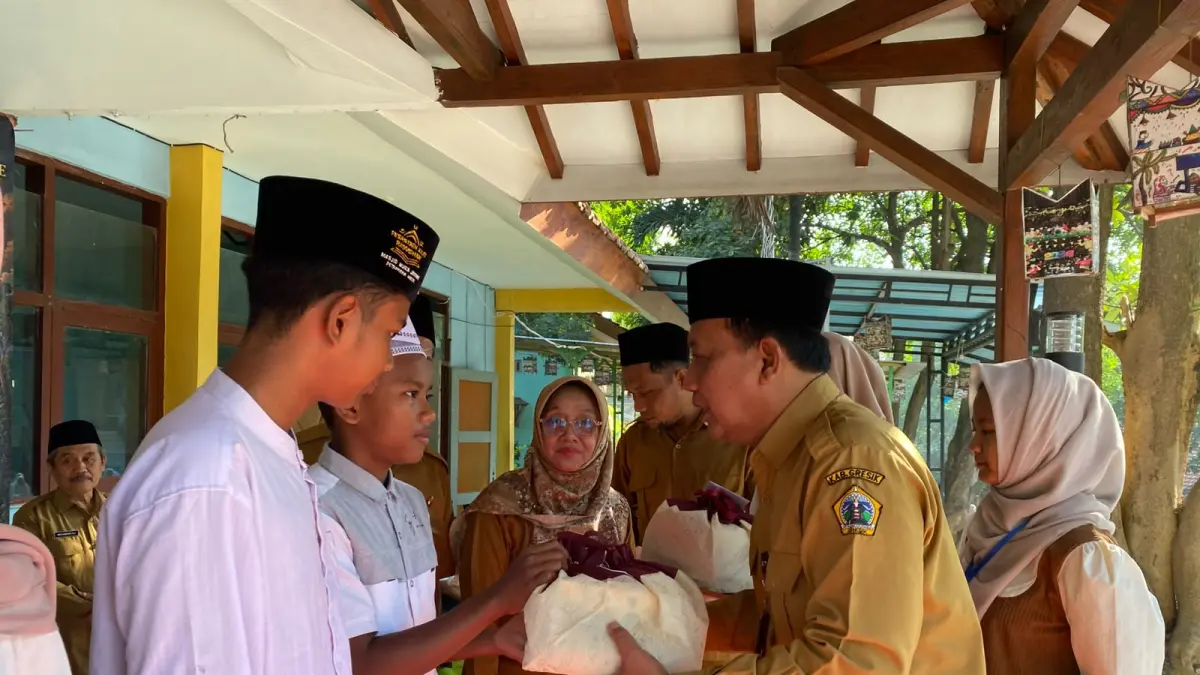 Kepala UPT SMPN 20 Gresik, Jumadi, S.Pd., M.Pd., memberikan santunan kepada siswa saat MPLS. (Foto : Ist/Radar Gresik) 