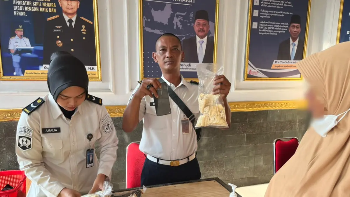 DIGAGALKAN : Petugas Rutan Kelas IIB Gresik saat menggagalkan penyelundupan dua buah Handphone yang disembunyikan di dalam roti oleh pengunjung. (Foto : Yudhi/Radar Gresik) 
