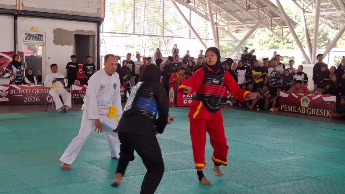 BERTARUNG : Para atlet pencak silat saat bertarung dengan memperagakan teknik seni silat. (Foto : Fajar/Radar Gresik) 