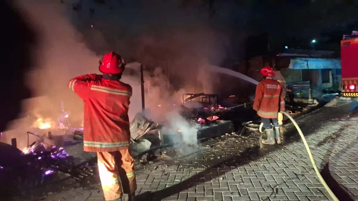 PEMADAMAN : Petugas Damkar Gresik saat melakukan pemadaman kebakaran sebuah warung di Desa Leran, Kecamatan Manyar, Gresik agar tidak merembet ke permukiman warga. (Foto : Ist/Radar Gresik) 