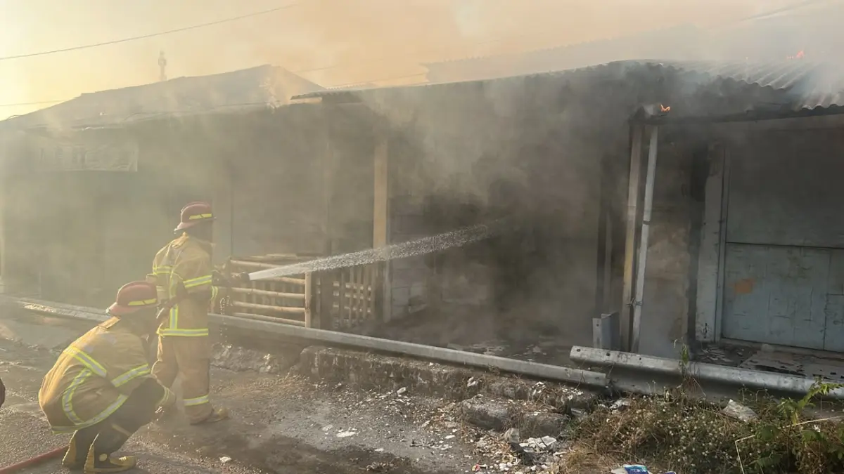 PEMADAMAN: Petugas Pos Damkar Dukun saat berjibaku melakukan pemadaman dan pendinginan pada ruko kosong yang terbakar akibat rembetan pembakaran sampah di area Pasar Dukun, Gresik. (Foto : Ist/Radar Gresik) 