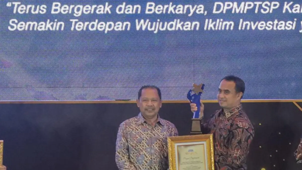 Foto : Kepala DPMPTSP Kabupaten Gresik A.M. Reza Pahlevi, A.P. (kanan) menerima penghargaan yang diserahkan Direktur Radar Surabaya, Lilik Widiantoro. (Andy Satria/Radar Surabaya).