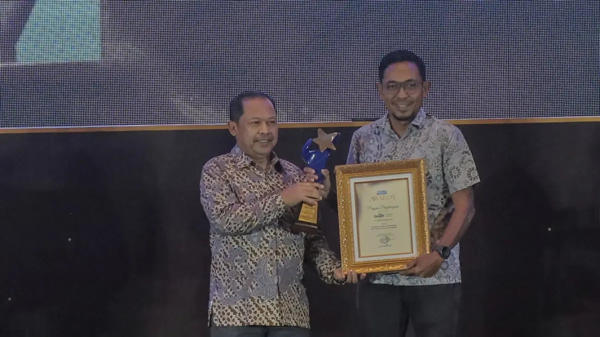 Direktur Radar Surabaya, Lilik Widiantoro, menyerahkan Piagam dan trophy Radar Surabaya Awards 2026 kepada Admin & Relations Manager Cargill Indonesia, Adi Suprayitno. (Foto : Dok/Radar Surabaya) 
