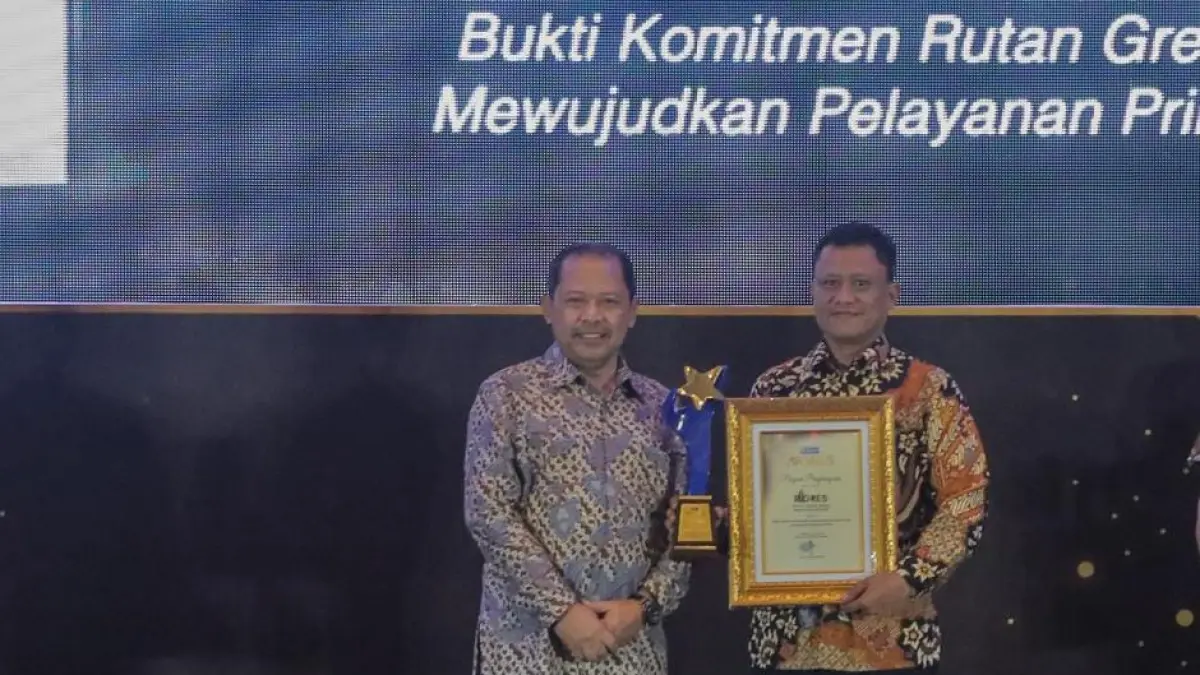 Kepala Rutan Kelas IIB Gresik Eko Widiatmoko (kanan) menerima penghargaan yang diserahkan Direktur Radar Surabaya, Lilik Widiantoro. (Foto : Andy Satria/Radar Surabaya)