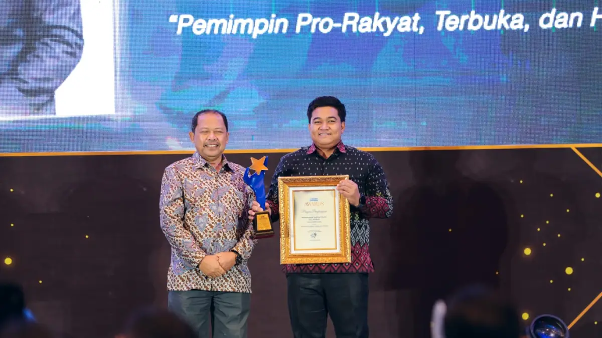 Ketua DPRD Kabupaten Gresik, M. Syahrul Munir, S.S., M.Hum. saat menerima penghargaan dari Direktur Radar Surabaya Lilik Widyantoro. (Dok/Radar Gresik)