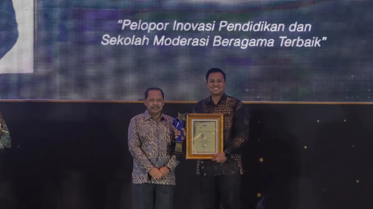 Trofi penghargaan diserahkan secara langsung oleh Direktur PT Radar Media Surabaya, Lilik Widyantoro, kepada Kepala SMA SIG, Choirul Fauzi. (Foto : Dok/Radar Surabaya) 