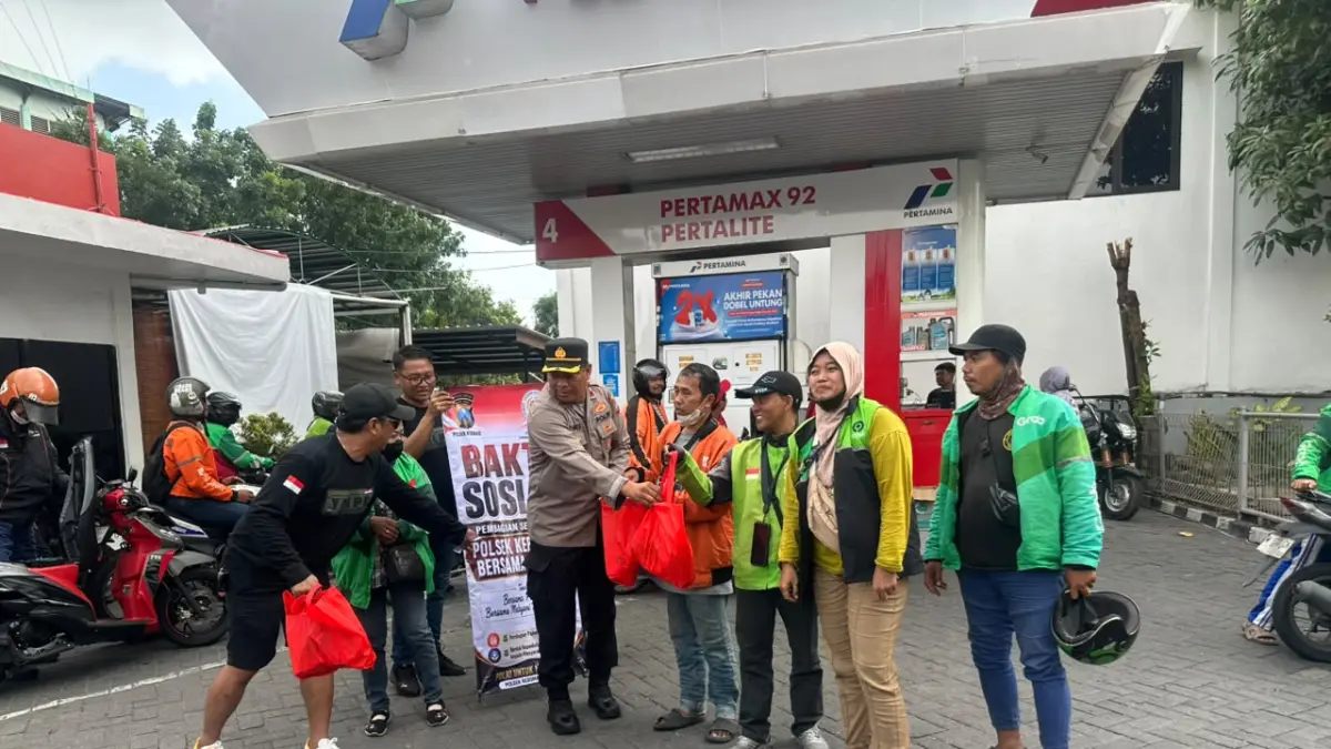 BAGIKAN SEMBAKO: Kapolsek Kebomas Kompol Tatak Sutrisno bersama jajaran saat membagikan sembako gratis untuk pengemudi ojol dan warga di sekitar SPBU Jalan Dr. Wahidin Sudirohusodo, Kebomas, Gresik. (Foto : Ist/Radar Gresik) 