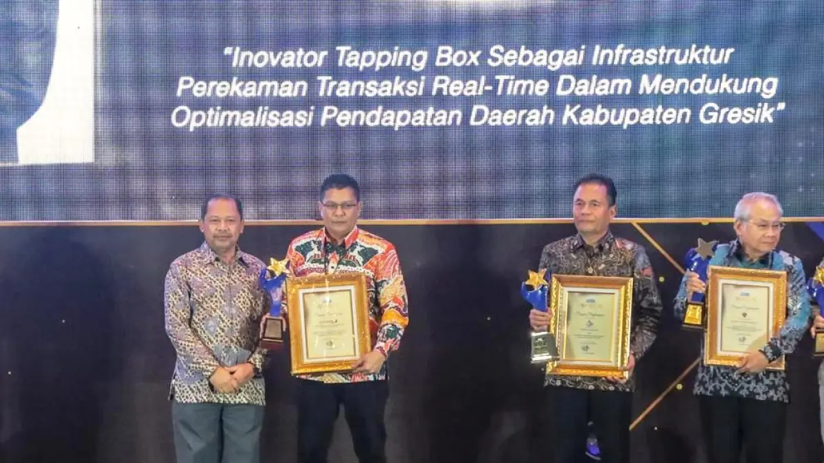 AKTIF BERKONTRIBUSI : Pemimpin Bank Jatim Cabang Gresik, Abdullah Basid, menerima penghargaan atas kontribusi Bank Jatim Cabang Gresik dalam menyediakan infrastruktur perekaman transaksi real-time untuk mengoptimalkan pendapatan daerah Kabupaten Gresik. (Sur/ Radar Surabaya)