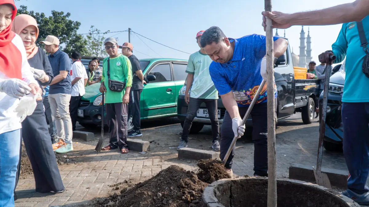 PENANAMAN : Bupati Gresik Fandi Akhmad Yani saat penanaman pohon di Gerakan Jumat Asri. (Foto : Fajar/Radar Gresik) 