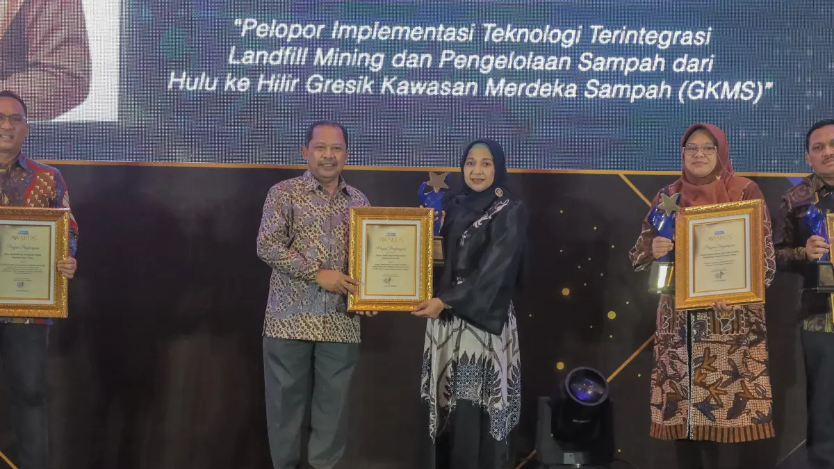 PENGHARGAAN: Kepala DLH Kabupaten Gresik Sri Subaidah saat menerima penghargaan Radar Surabaya Awards 2026 atas inovasi pengelolaan sampah terintegrasi. (Foto : Dok/Radar Gresik) 