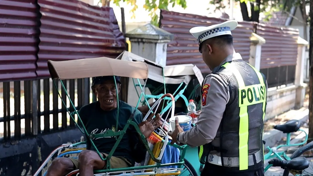 BERBAGI: Anggota Satlantas Polres Gresik saat membagikan paket nasi hangat kepada pengemudi becak dan pekerja jalanan di wilayah Kota Gresik. (Foto : Yudhi/Radar Gresik) 