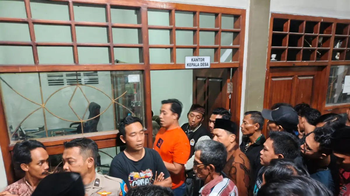 PENGAMANAN: Anggota Polsek Bungah saat mengamankan terduga pasangan selingkuh dari kepungan warga di Balai Desa Abar-Abir, Kecamatan Bungah, Gresik. (Foto : Ist/Radar Gresik) 