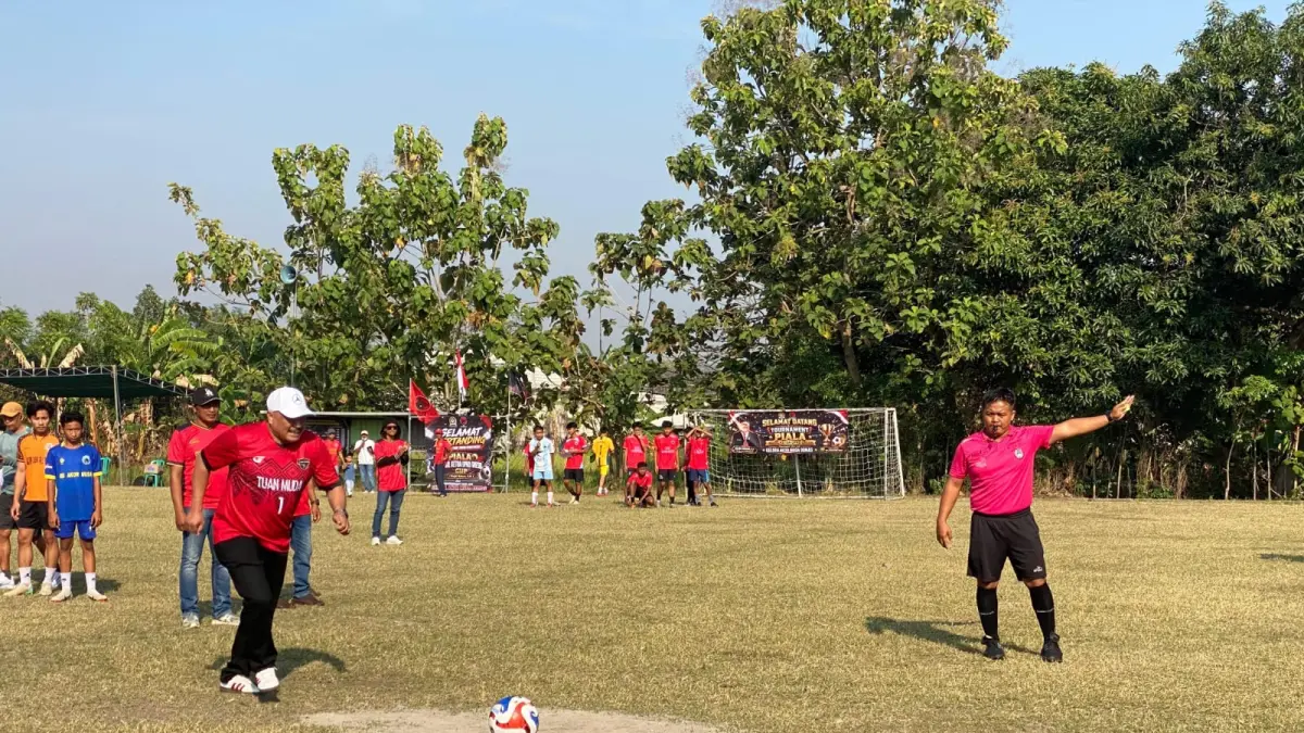 MENENDANG: Wakil Ketua DPRD Gresik, Mujid Riduan saat menendang bola ke gawang lawan. (Foto : Fajar/Radar Gresik) 