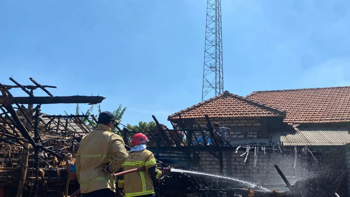 PENYEMPROTAN: Petugas Damkarla Gresik Pos Dukun saat melakukan proses pembasahan di area kandang kambing yang terbakar di Desa Pantenan, Kecamatan Panceng, Gresik. (Foto : Ist/Radar Gresik) 