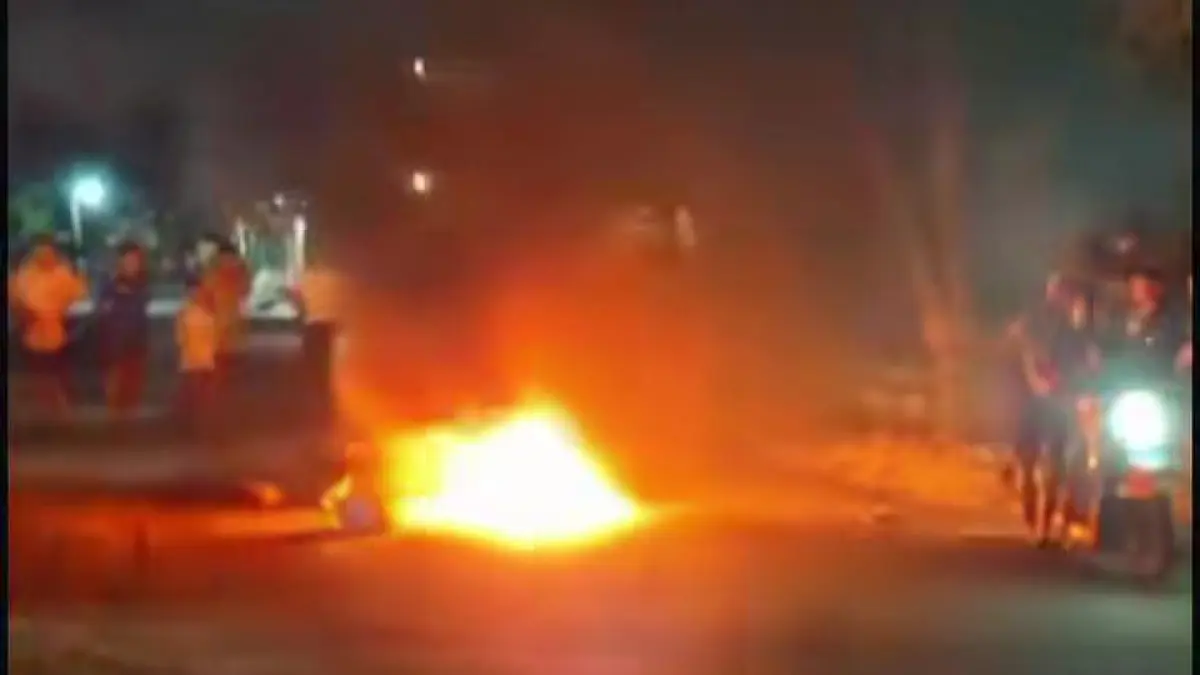 DIBAKAR: Sepeda motor pelaku AR saat dibakar massa dan polisi mengamankan pelaku beserta barang bukti uang diduga hasil mencuri. (Foto : Ist/Radar Gresik) 