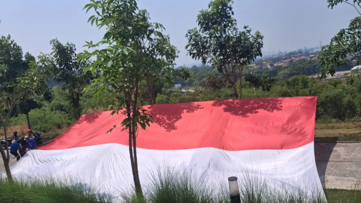 BENDERA RAKSASA : Pegiat UMKM, pemuda, dan warga Gresik mengibarkan bendera Merah Putih berukuran raksasa berukuran 15x9 meter  di kawasan Tanatuju, Jalan Dewi Sekardadu, Gunungsari. 