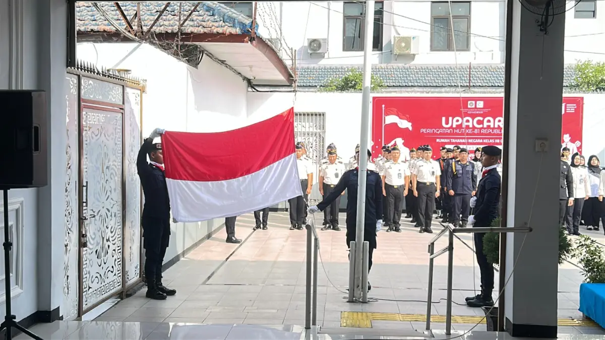 PENGIBARAN BENDERA : Petugas Rutan Kelas IIB Gresik saat mengibarkan bendera merah putih saat upacara peringati HUT Kemerdekaan RI Ke 81 di didalam balik jeruji. (Foto : Yudhi/Radar Gresik) 
