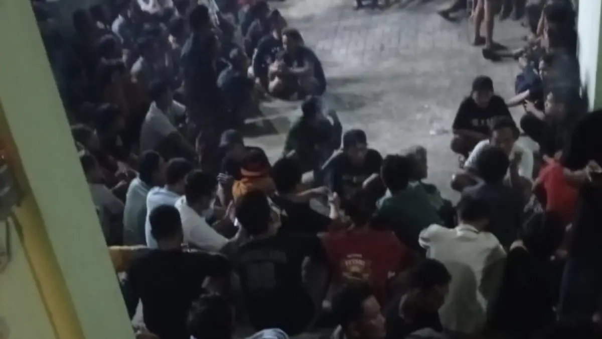 DIAMANKAN : Dua oknum Polsek Duduksampeyan Briptu P dan Brigpol D  saat diamankan di kantor Balai Desa Petung oleh petugas saat ratusan warga saat berkumpul di Balai Desa Petung, Kecamatan Panceng, Gresik. ( Foto : Ist/Radar Gresik) 