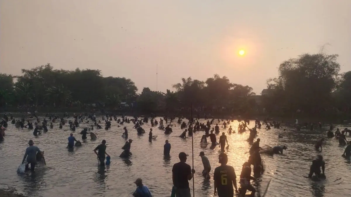 BERGEMBIRA: Ratusan warga antusias dan bergembira saat menangkap ikan gratis dalam tradisi Ngubek Srumbung di Waduk Srumbung, Desa Bulangan, Dukun, Gresik. (Foto: DOK/Radar Gresik)