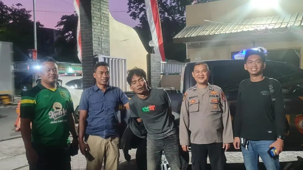 DIAMANKAN : Pelaku DS saat diamankan dan dievakuasi dari amukan masa oleh anggota Polsek Driyorejo, Gresik. (Foto : Ist/Radar Gresik) 