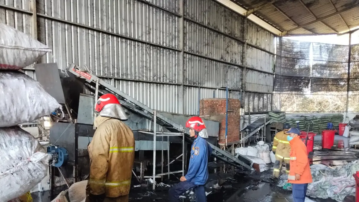 PEMADAMAN : Petugas Damkar Gresik saat melakukan pemadaman api dari mesin tungku yang menyebabkan kebakaran arang di area pergudangan PT EPL Suplay Chain, Kecamatan Manyar, Gresik. (Foto : Ist/Radar Gresik) 