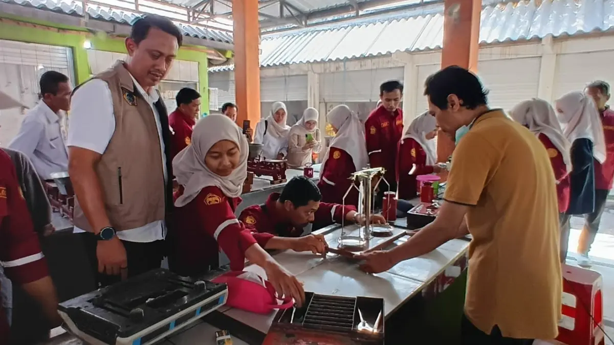 TIMBANGAN : Plt Kepala UPT Metrologi Legal Diskoperindag Gresik, Trisno Yadi Setyawan saat uji tera timbangan di Pasar Duduksampeyan, Gresik. (Foto : Fajar/Radar Gresik) 