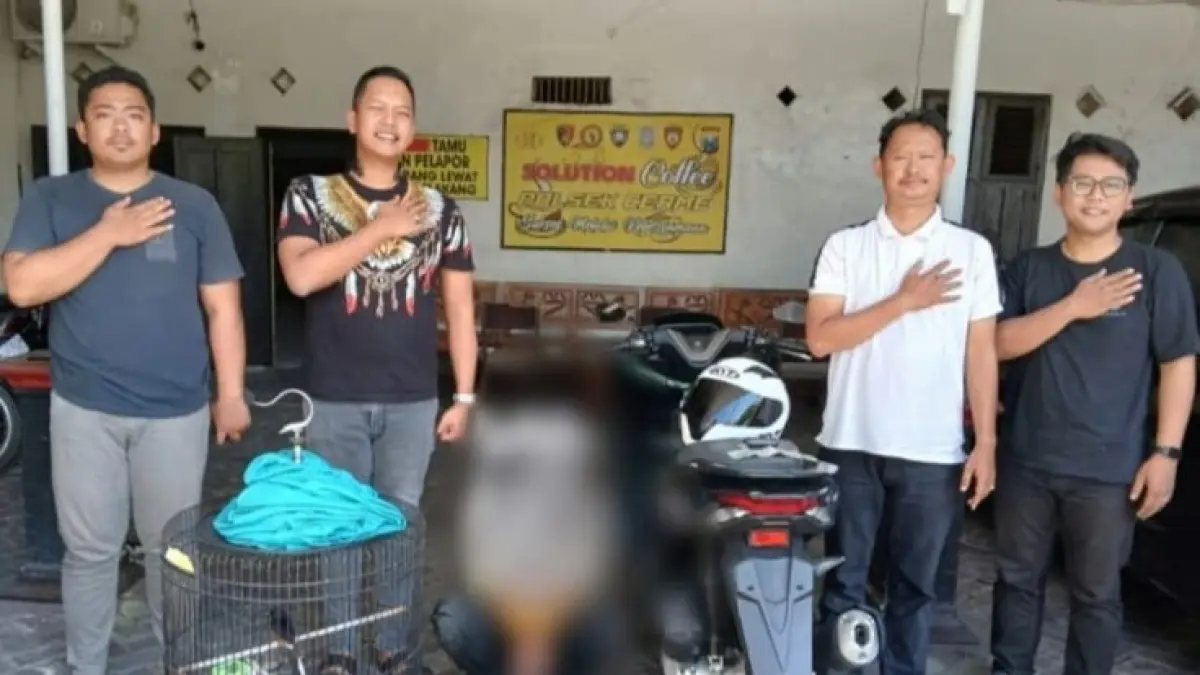 DIAMANKAN: Anggota Unit Reskrim Polsek Cerme memperlihatkan barang bukti seekor burung murai batu beserta sangkarnya. (Foto : Ist/Radar Gresik) 