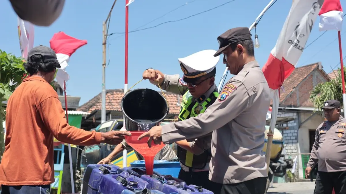 BAGIKAN AIR : Anggota Polres Gresik saat salurkan bantuan air bersih untuk Warga tiga Desa terdampak kekerigan di Kecamatan Balongpanggang, Gresik. (Foto : Ist/Radar Gresik) 