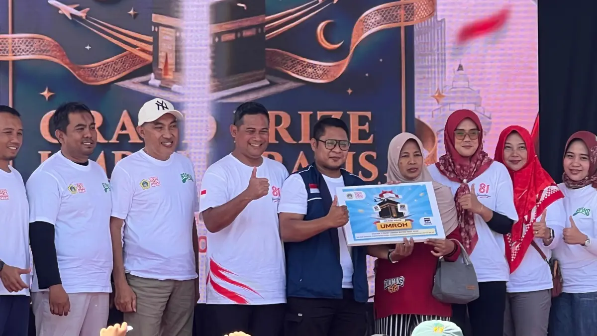 HADIAH UTAMA : Siti Fatimah, warga RT 3 RW 2 Desa Yosowilangun, menerima penyerahan secara simbolis paket ibadah umrah gratis dari Kepala Desa Yosowilangun, Abdur Rosyid (keempat dari kiri), beserta perwakilan penyelenggara di atas panggung utama. (Foto : Riri/Radar Gresik) 