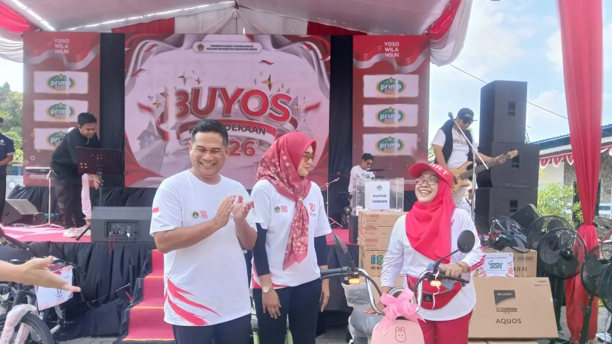 MERIAH : Kepala Desa Yosowilangun, Abdur Rosyid didampingi Ketua TP PKK Yosowilangun, Dwi Ariyanti menyerahkan doorprize berupa satu unit sepeda listrik kepada salah satu warga penerima hadiah di panggung utama perayaan Buyos Kemerdekaan 2026. (Foto : Riri/Radar Gresik) 